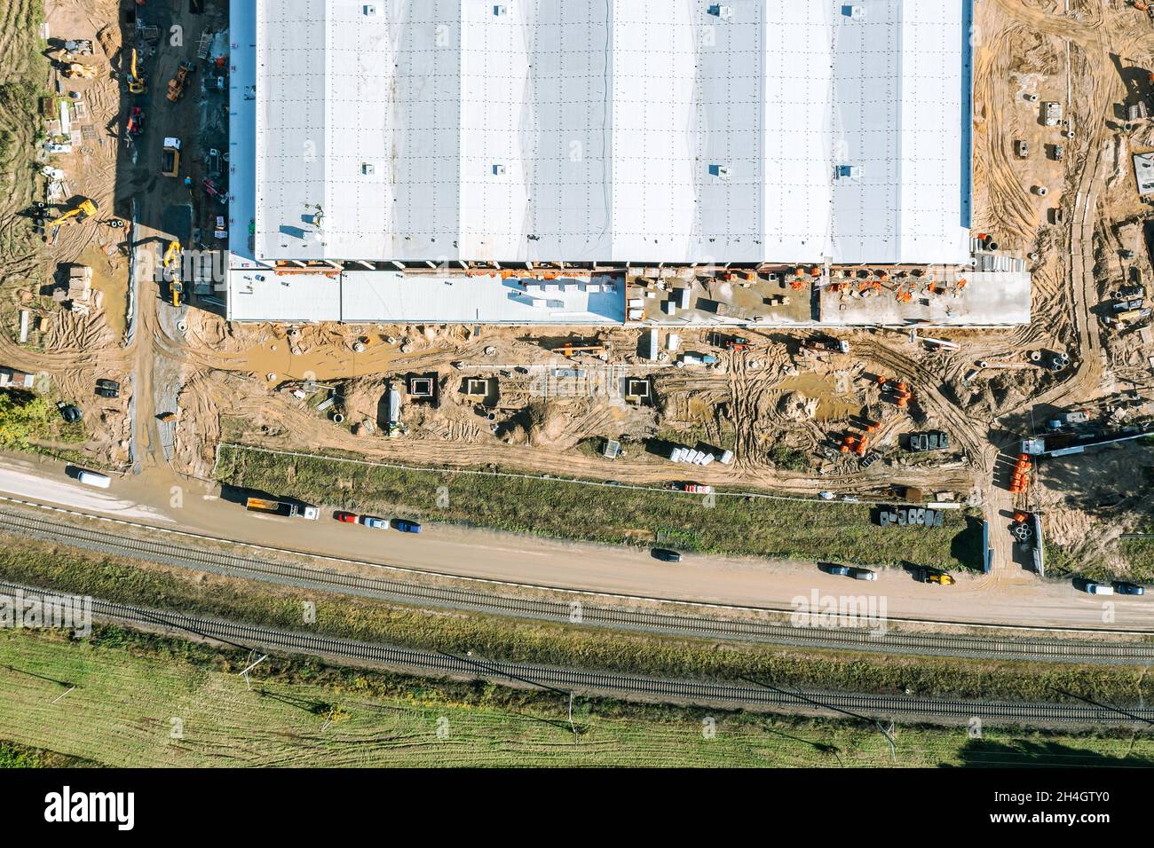 vue aérienne de dessus d'un entrepôt ou d'un bâtiment industriel en construction à côté d'un chemin de fer Banque D'Images