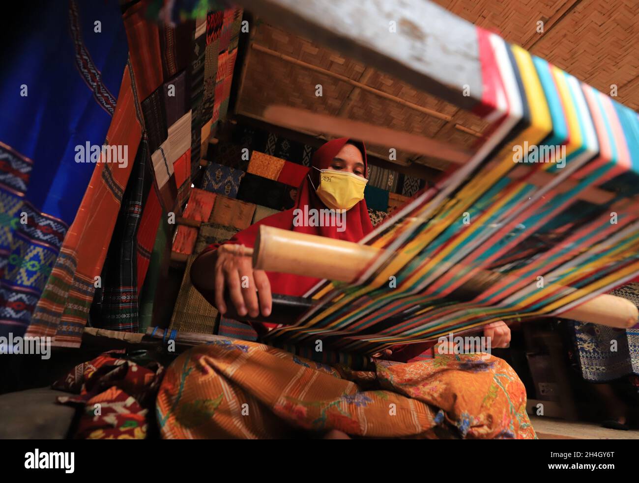 Lombok, West Nusa Tenggara, Indonésie-Oct 25, 2021: Une femme est en train de tisser à l'aide d'un métier à tisser traditionnel Banque D'Images