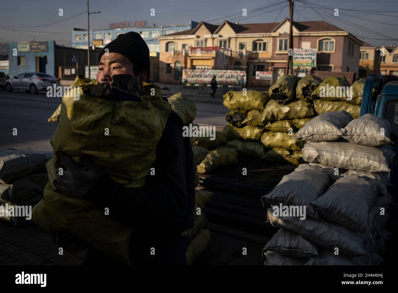 Un homme empile des sacs de charbon à vendre aux résidents de la capitale Oulan-Bator dans un marché de charbon de la ville, le 15 janvier 2019.Ulaanbaatar se classe comme Banque D'Images