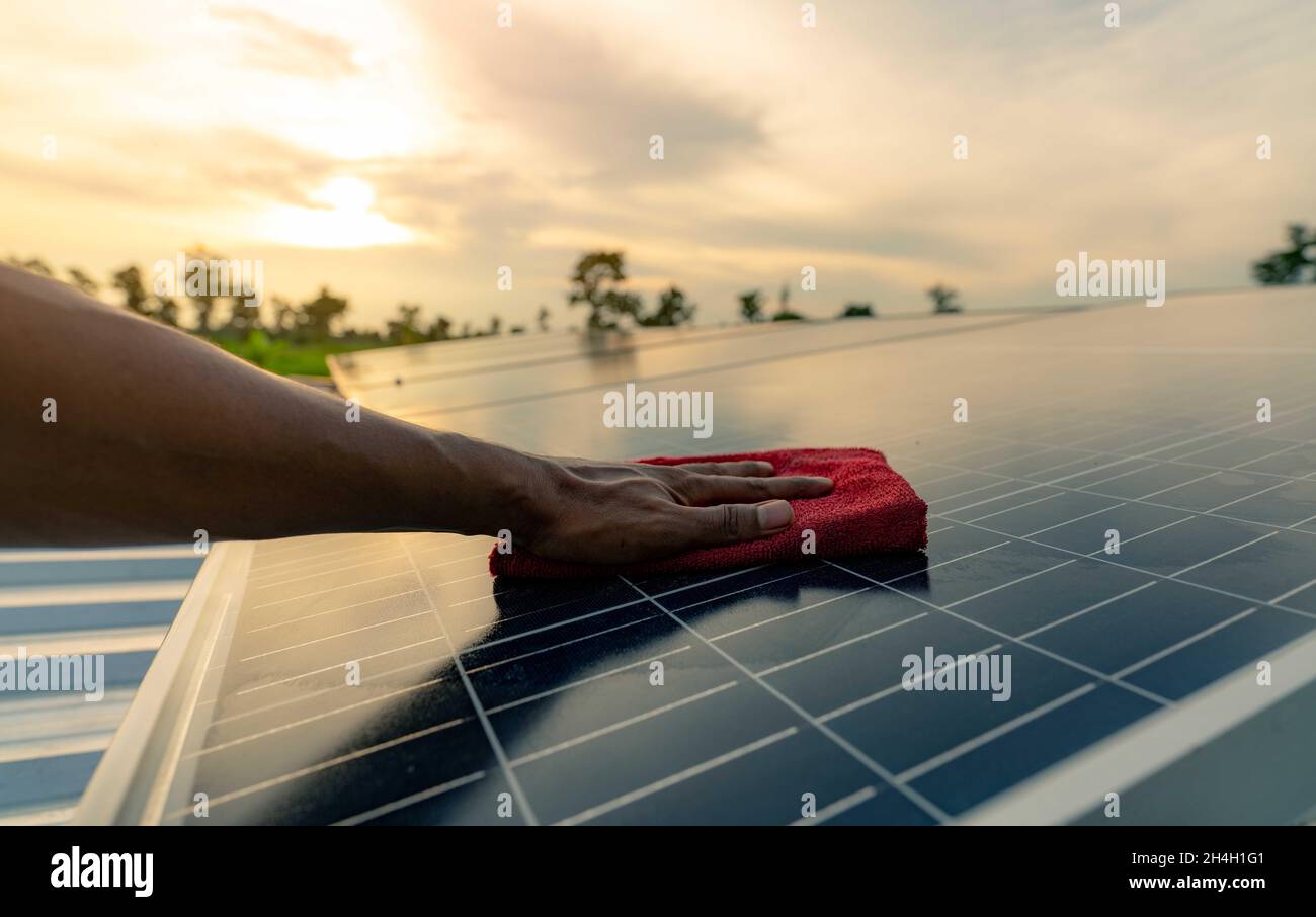 Homme nettoyant le panneau solaire sur le toit.Maintenance du panneau solaire ou du module photovoltaïque.Ressources durables et énergies renouvelables pour le concept « Go green ». Banque D'Images