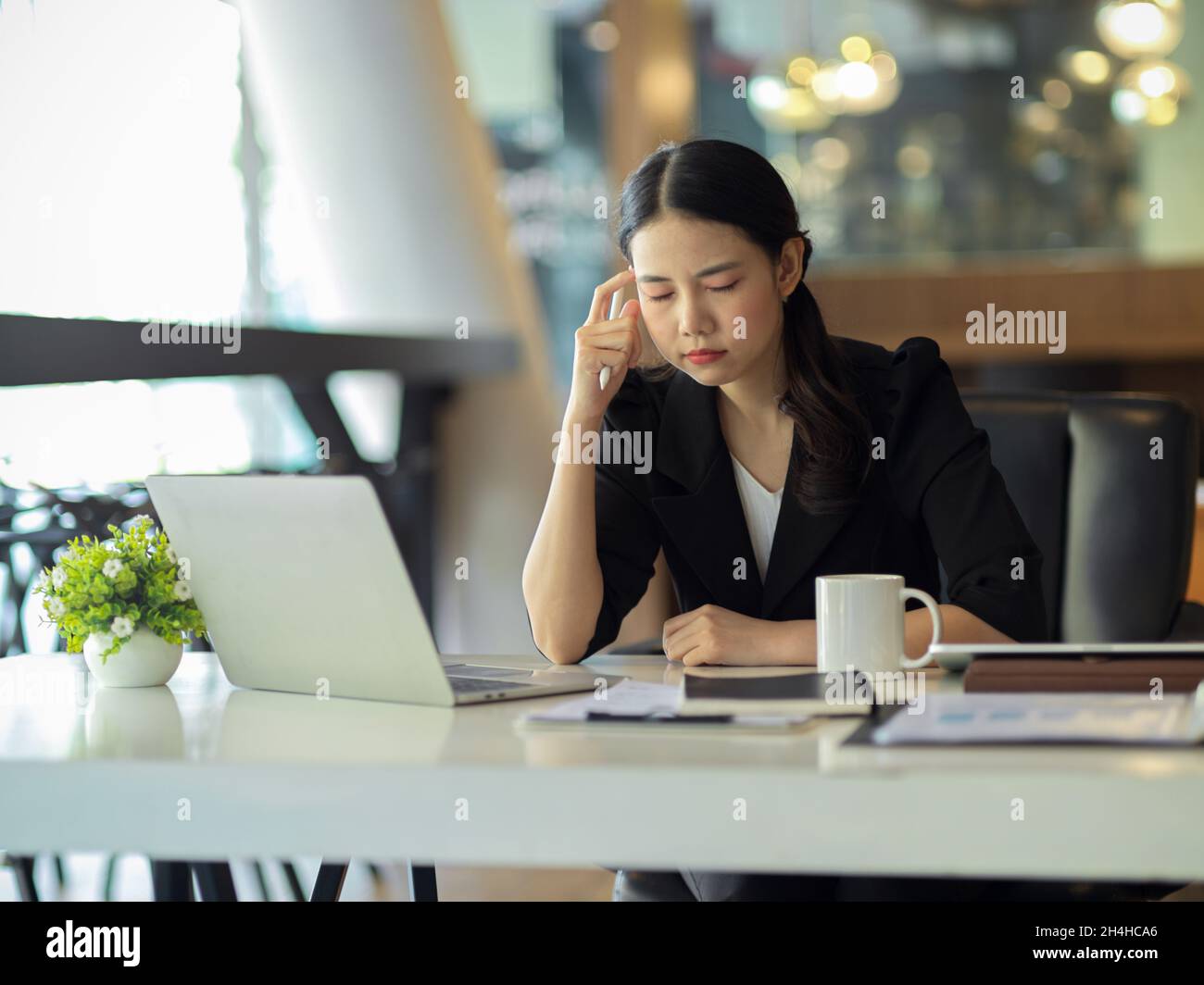 Une femme d'affaires a un mal de tête en essayant de résoudre des problèmes au travail.Femme directrice au bureau. Banque D'Images