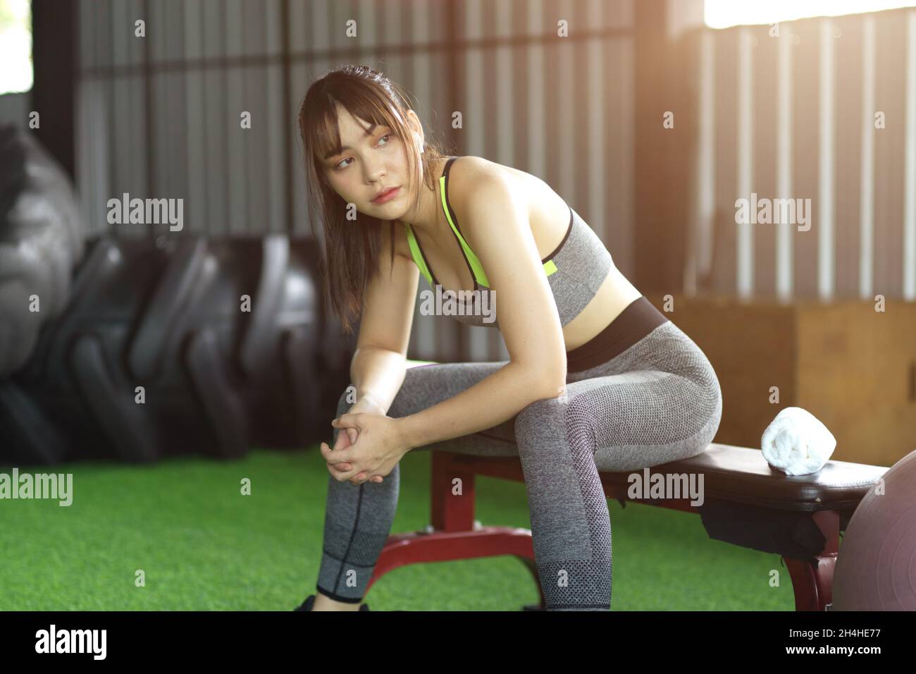 Belle femme de fitness assise sur une chaise et se reposant après l'entraînement au centre de fitness.Une femme fait une pause après un cardio dur. Banque D'Images