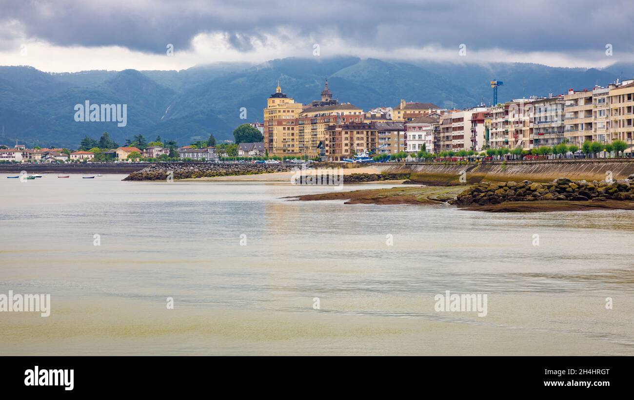 Vue panoramique sur la promenade de Hondarribia depuis la mer par temps pluvieux à marée basse. Banque D'Images