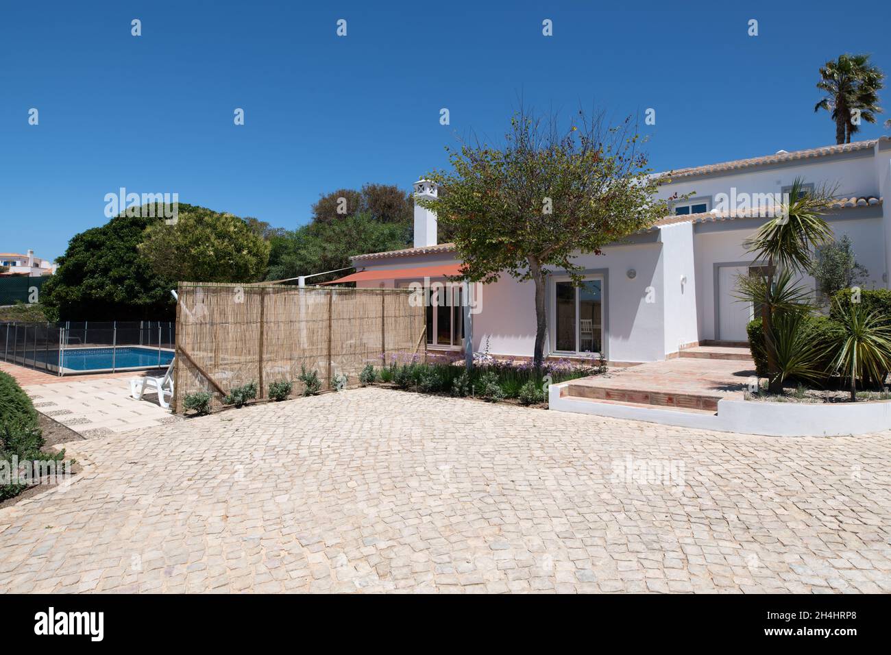 Entrée principale de la villa portugaise blanche avec arbres et tuiles de calcada Banque D'Images