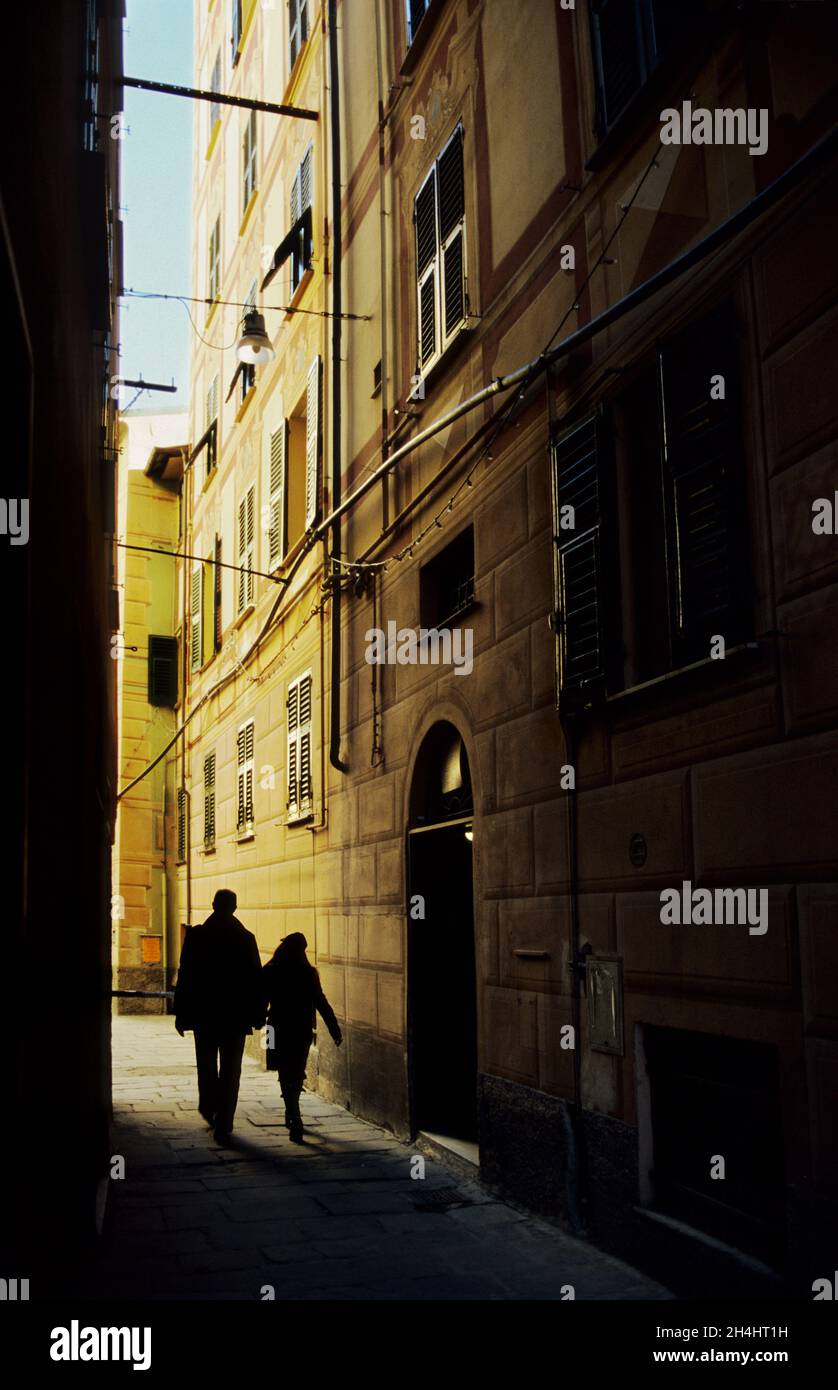 Photo verticale d'étrangers marchant dans la rue étroite.Finale Ligure, Italie Banque D'Images