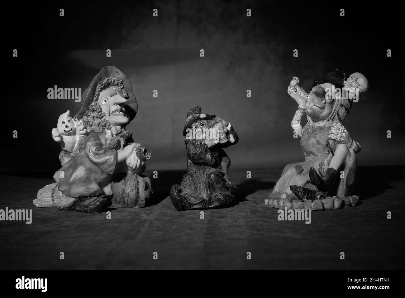 Gros plan en niveaux de gris de souvenirs d'Halloween sur le thème des personnages tenant des crânes Banque D'Images