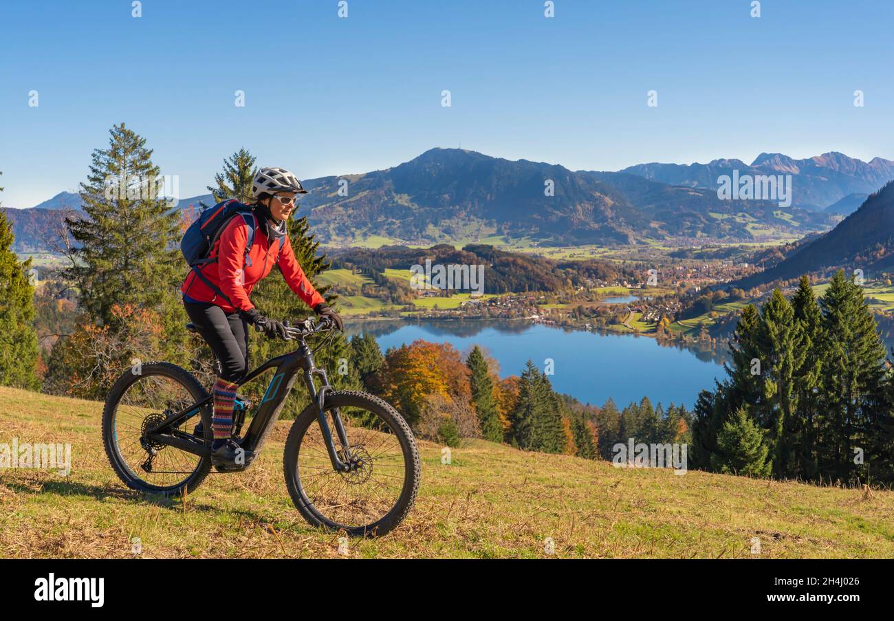 Belle femme avec vélo électrique de montagne appréciant la vue sur le lac  Alpsee dans une atmosphère d'atumnal dans les alpes d'Allgaeu au-dessus  d'Immenstadt, Alp bavarois Photo Stock - Alamy