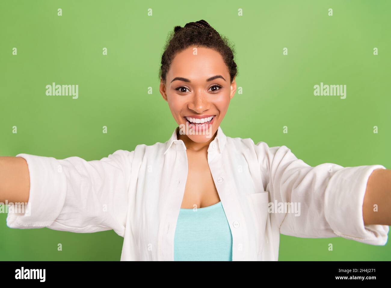 Photo portrait femme avec un petit pain coiffure sourire prenant selfie isolé pastel vert couleur fond Banque D'Images