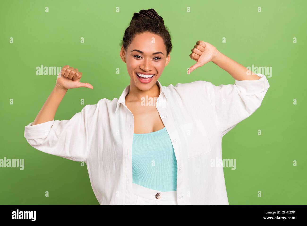 Photo portrait femme avec une coiffure de pain pointant le pouce sur elle-même isolé pastel vert couleur fond Banque D'Images