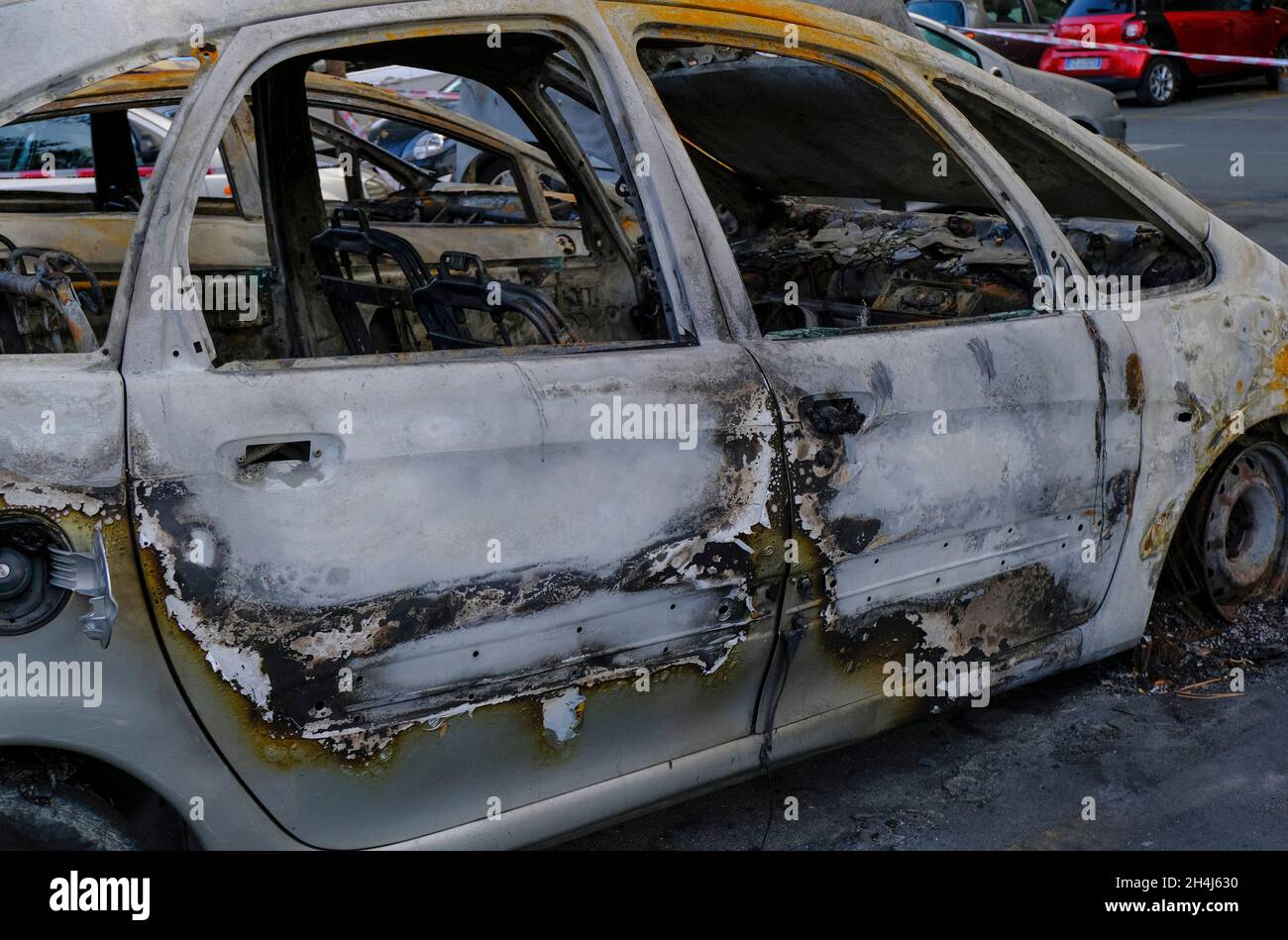 Porte de voiture brûlée dans la rue en gros plan.Émeute, protestation civile, hooliganisme, criminel dans la ville. Banque D'Images