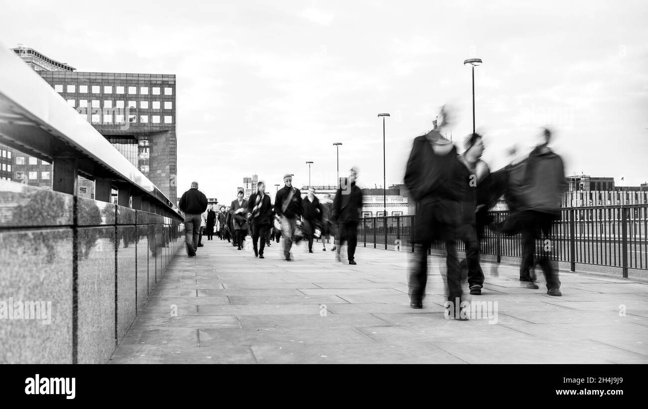 La vitesse de l'entreprise.Vue abstraite créative du trafic piétonnier traversant le London Bridge pendant les heures de pointe matinales. Banque D'Images