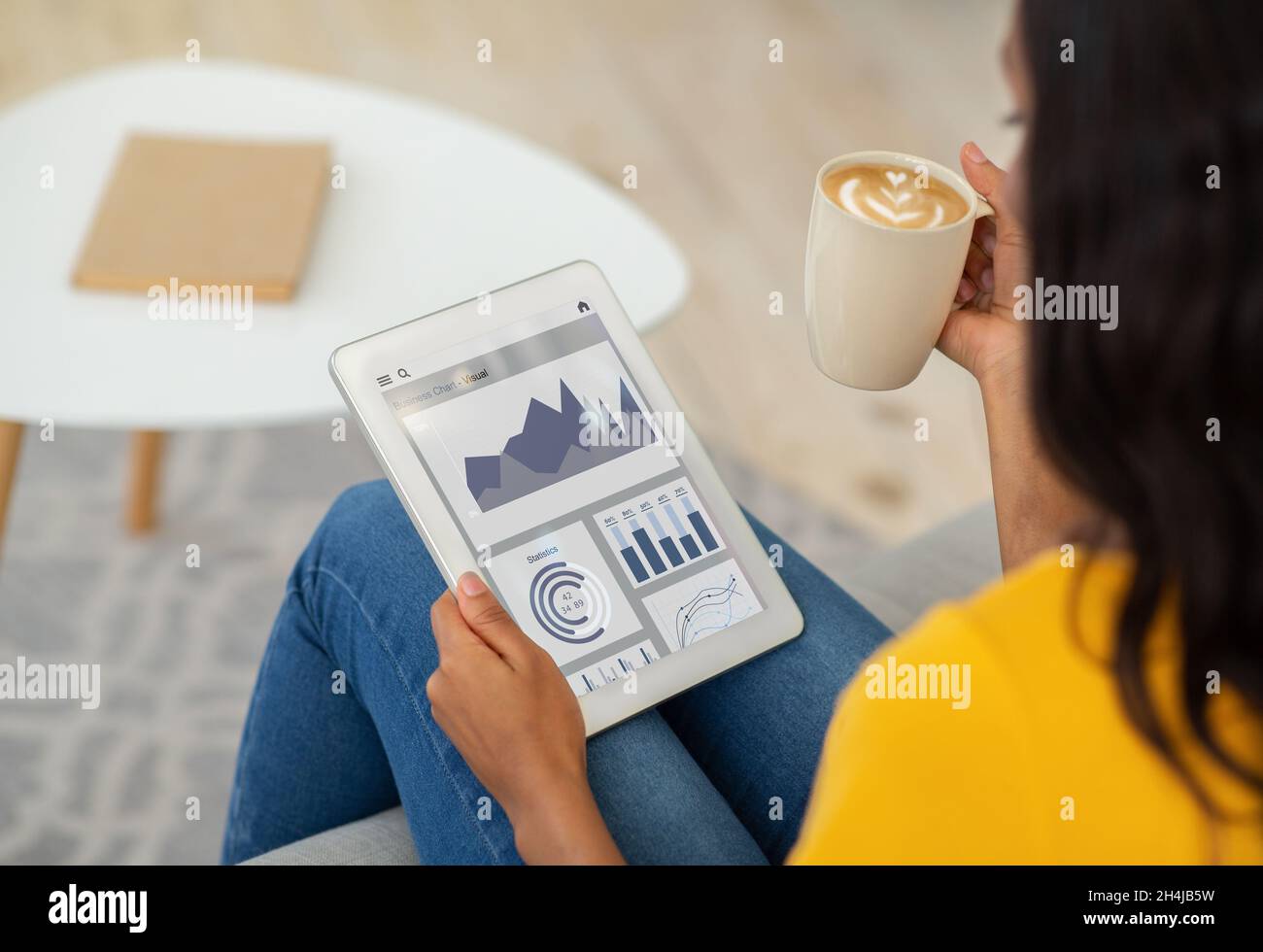 Jeune femme noire se détendant à la maison, buvant un café et vérifiant l'application passive de revenu à temps libre, collage Banque D'Images