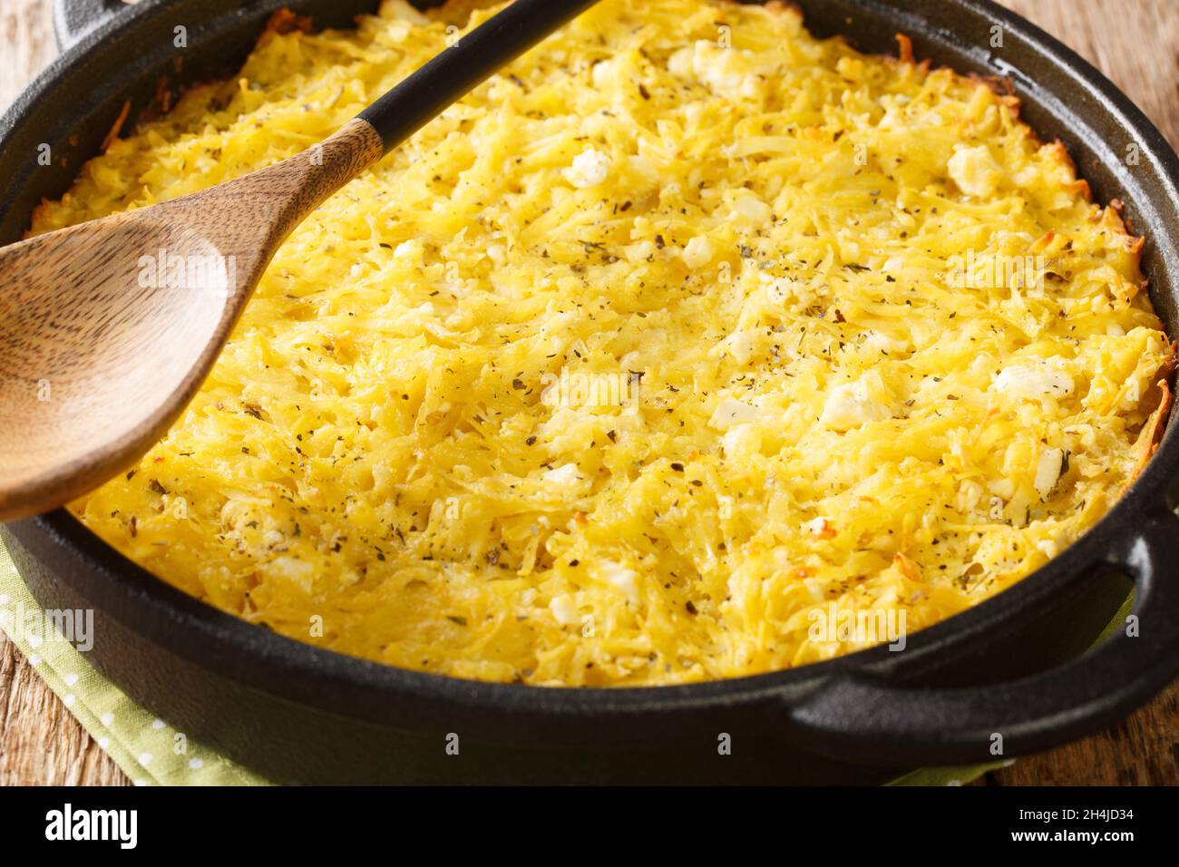 Tarte bulgare aux pommes de terre Patatnik avec oignons, fromage et œufs dans une poêle à frire sur la table. Horizontale Banque D'Images