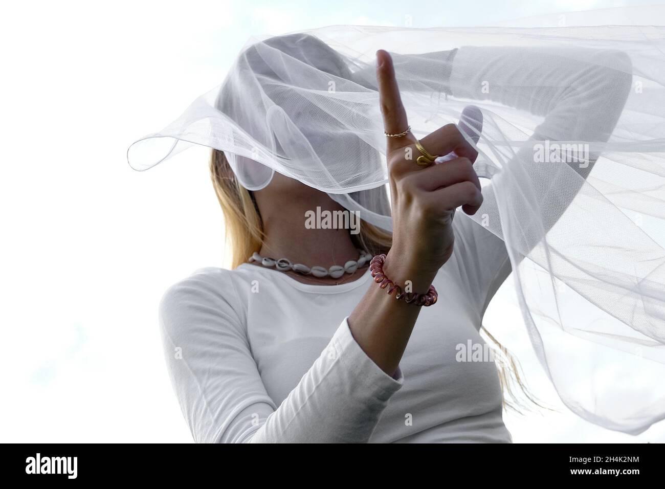 Portrait d'une adolescente avec un morceau de tissu fin couvrant son visage, France Banque D'Images