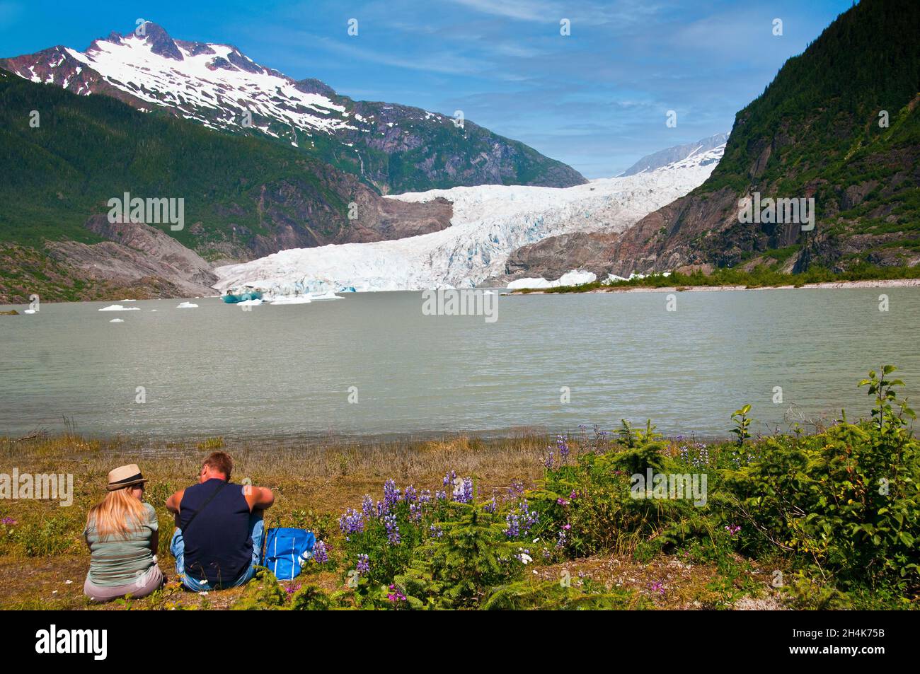 Couple reposant sous le glacier Mendenhall, Juneau, Alaska Banque D'Images