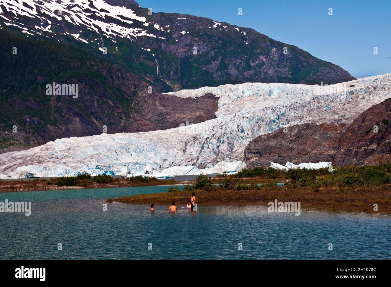 Quatre garçons nageant dans des eaux glacielles sous le glacier Mendenhall, Juneau, Alaska Banque D'Images