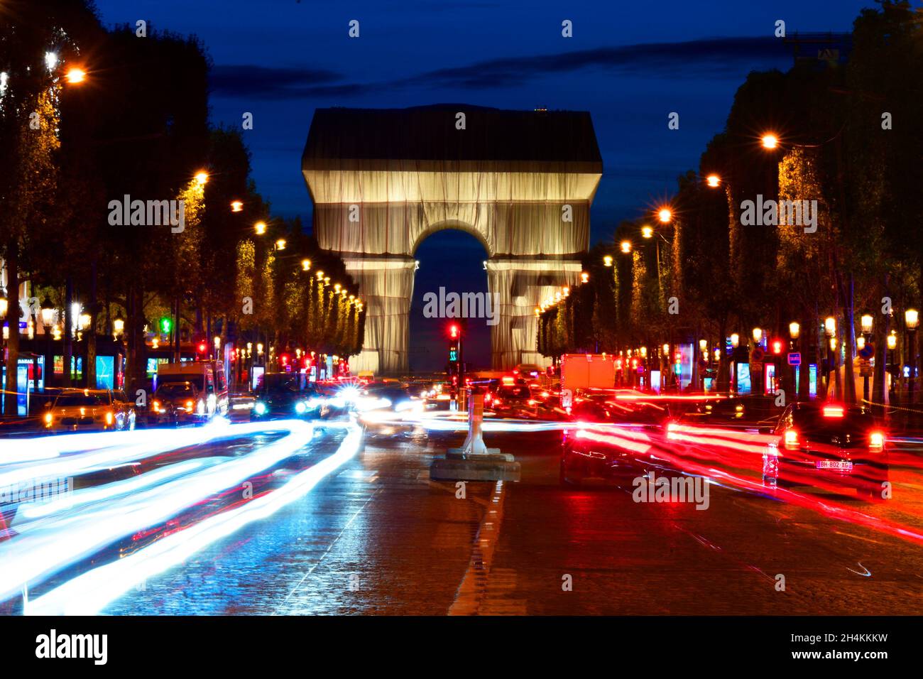 Vue nocturne de l'arche triomphale enveloppée de Christo depuis l'avenue des champs-Élysées, Paris, France. Banque D'Images