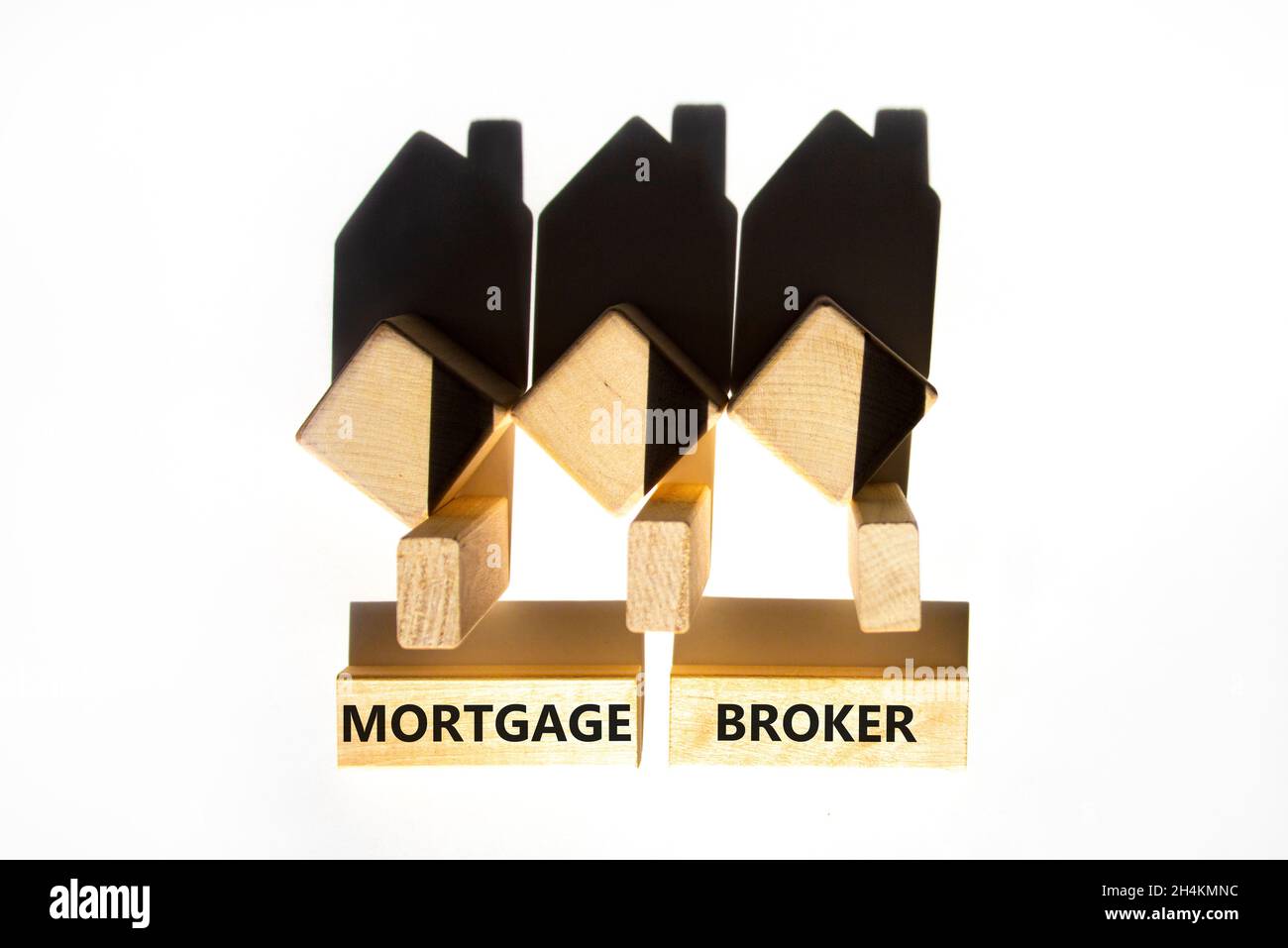 Symbole de courtier hypothécaire.Concept mots 'Mortgage broker' sur des blocs de bois près de maisons miniatures en bois de l'ombre.Magnifique fond blanc.Buline Banque D'Images