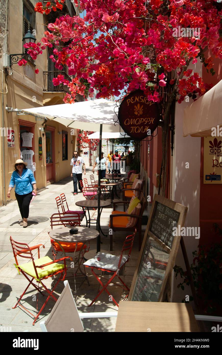 Nafplio - Grèce - Mai 25 2018 : petit café dans une rue colorée au coeur de la vieille ville historique de belles fleurs ina allée ombragée V Banque D'Images