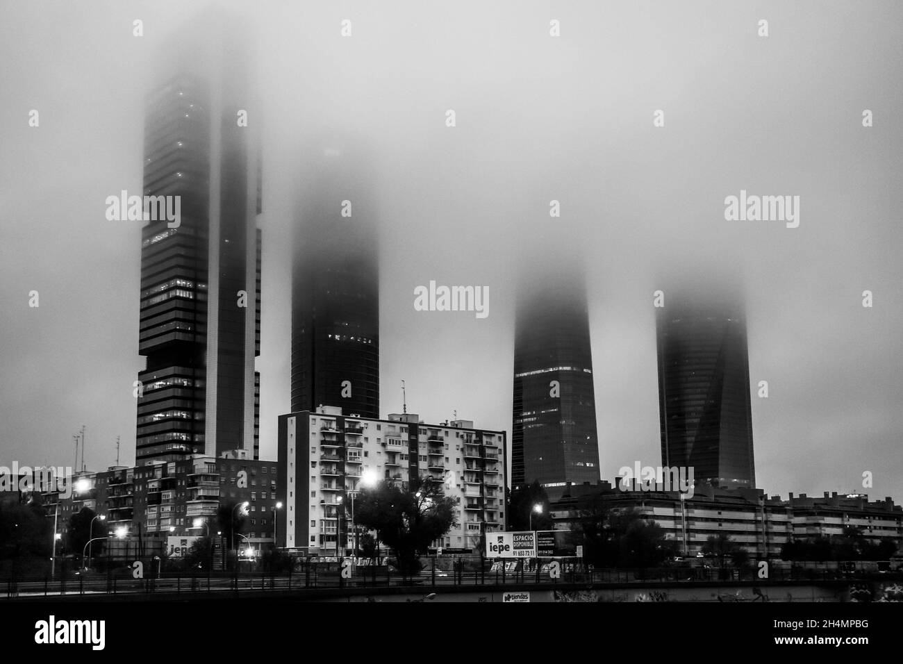 Le quartier des affaires de Cuatro Torres avec ses quatre tours entourées de brouillard le matin, vu de la gare de Chamartin, à Madrid, en Espagne. Banque D'Images