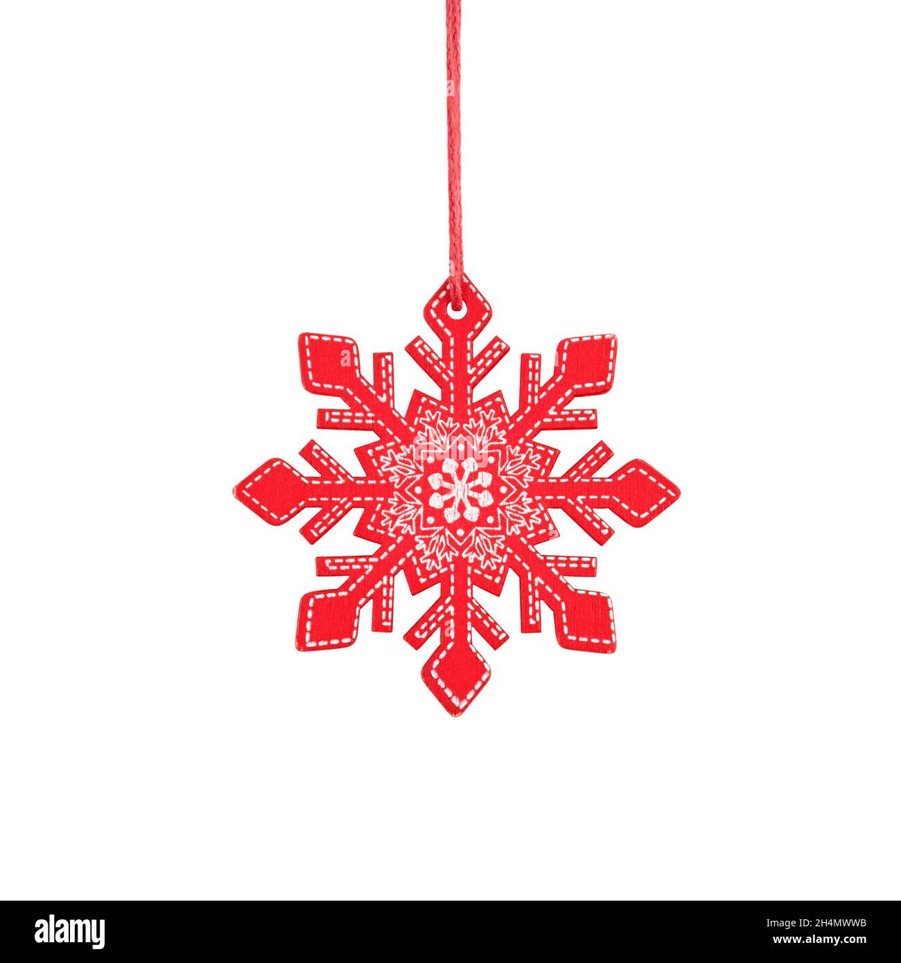 Flocon de neige en bois rouge suspendu, décoration rustique d'arbre de Noël isolée sur fond blanc. Banque D'Images