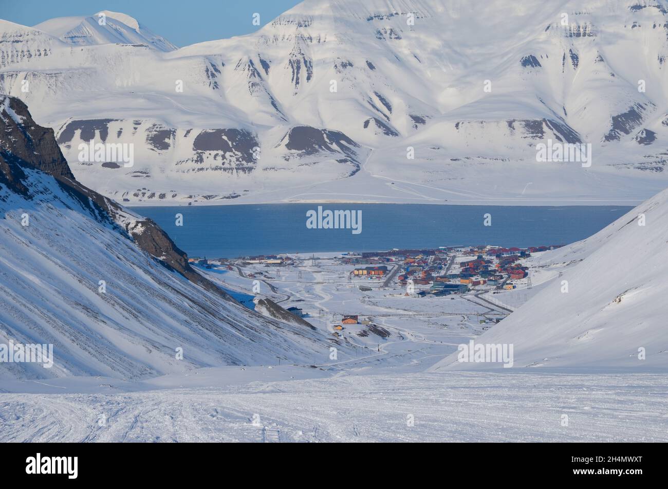 La beauté magique de Svalbard. Neige exceptionnellement bleue contre le ciel dégagé. Village minier près du fjord sur l'île de Svalbard Banque D'Images