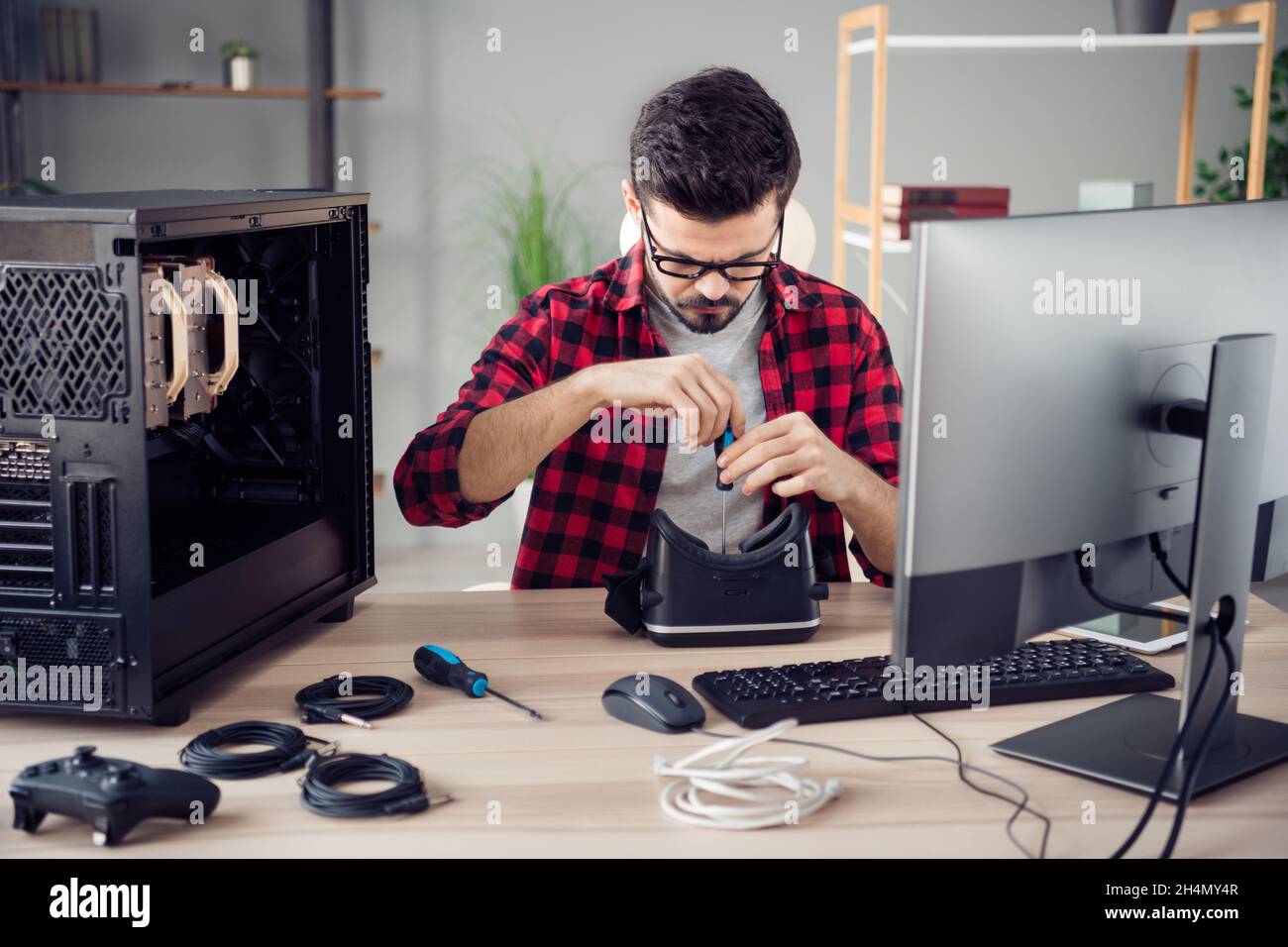 Portrait d'un homme compétent et intelligent et attrayant qui fixe la garantie du cyberespace vr au poste de travail en salle Banque D'Images