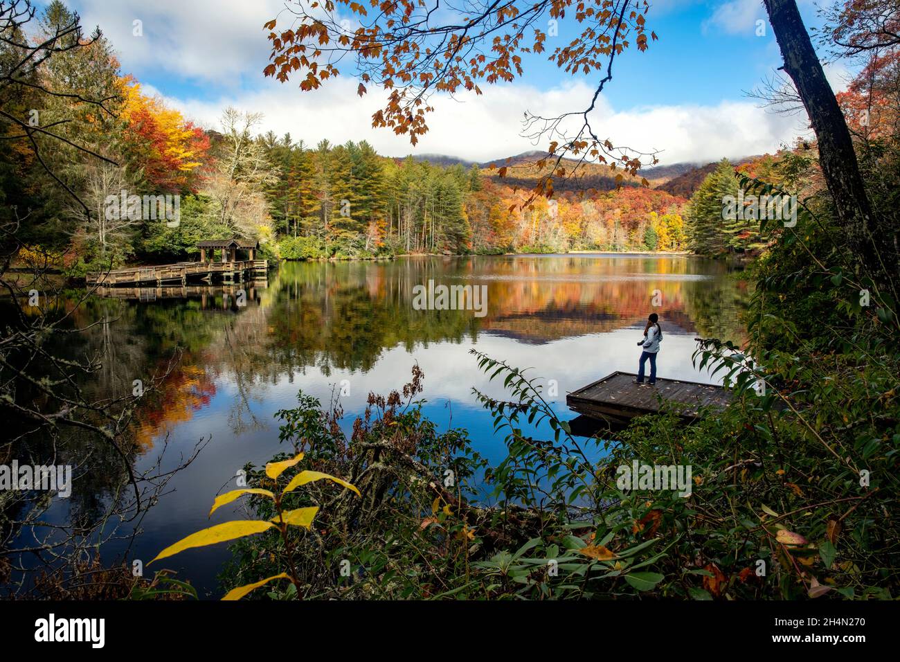 Femme à quai dans un paysage d'automne dynamique - Lac Balsam, Forêt Roy Taylor dans la forêt nationale de Nantahala, Canada, Caroline du Nord, États-Unis Banque D'Images