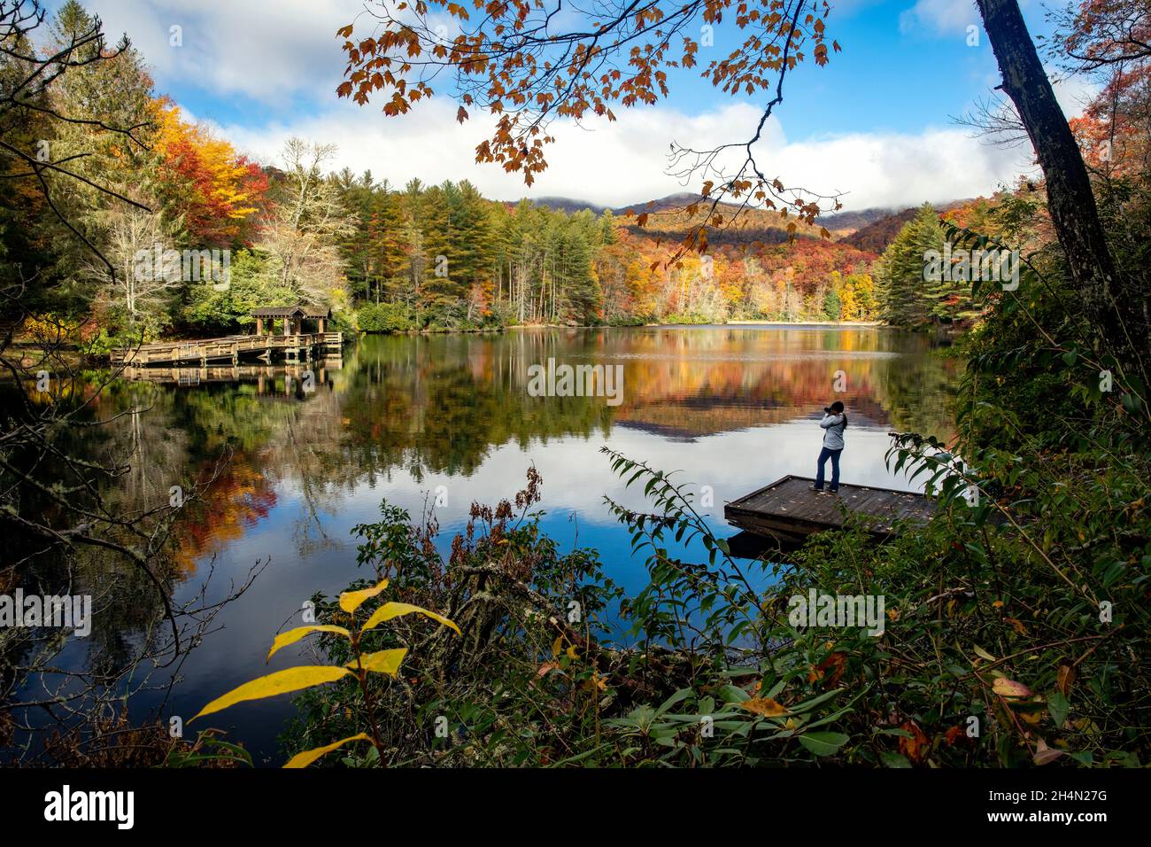 Femme à quai dans un paysage d'automne dynamique - Lac Balsam, Forêt Roy Taylor dans la forêt nationale de Nantahala, Canada, Caroline du Nord, États-Unis Banque D'Images