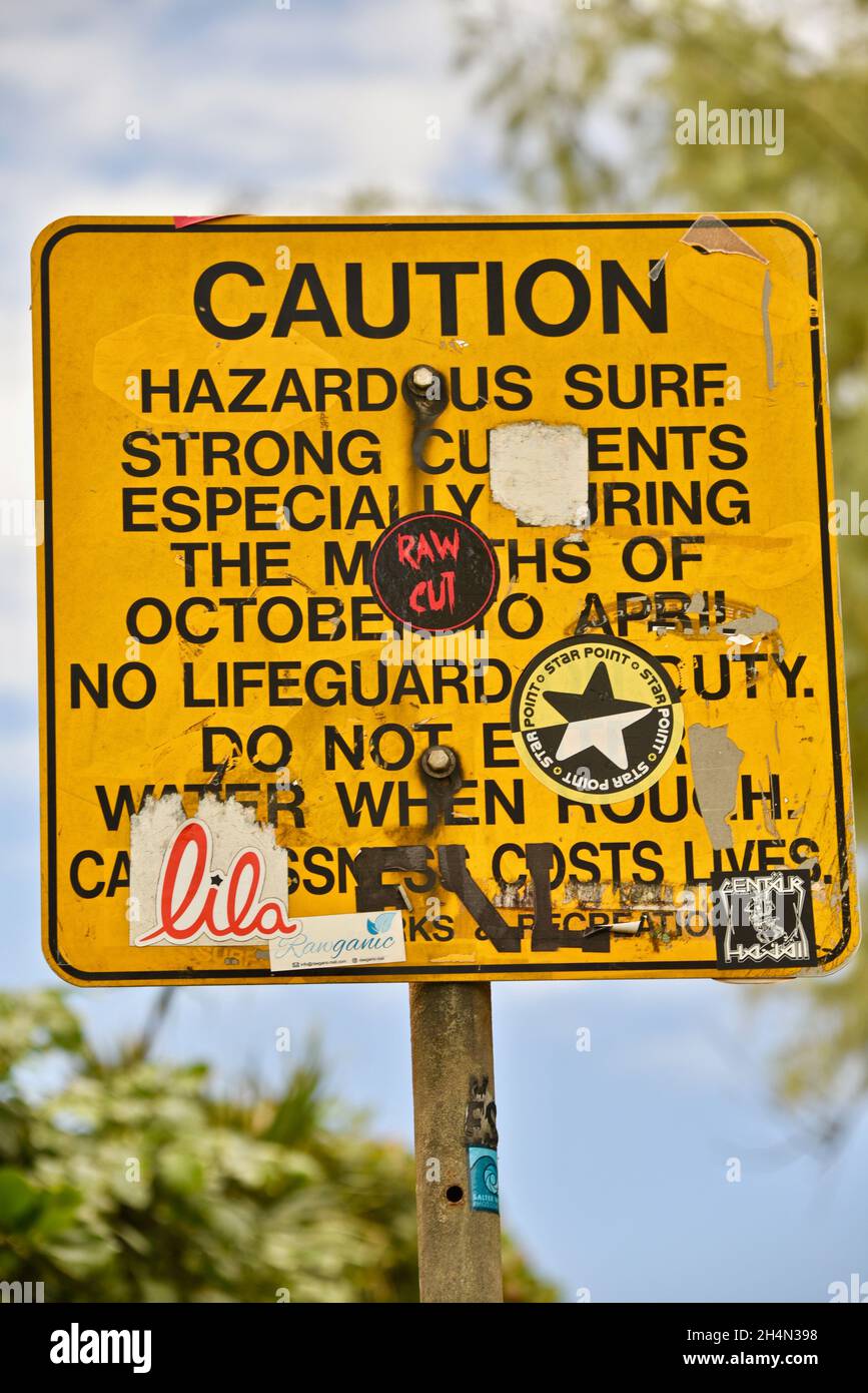 Graffiti, autocollants pare-chocs et autres autocollants couvrant et plâtant sur les vagues dangereuses attention panneau Surf dangereux sur Oahu, Hawaii, États-Unis Banque D'Images