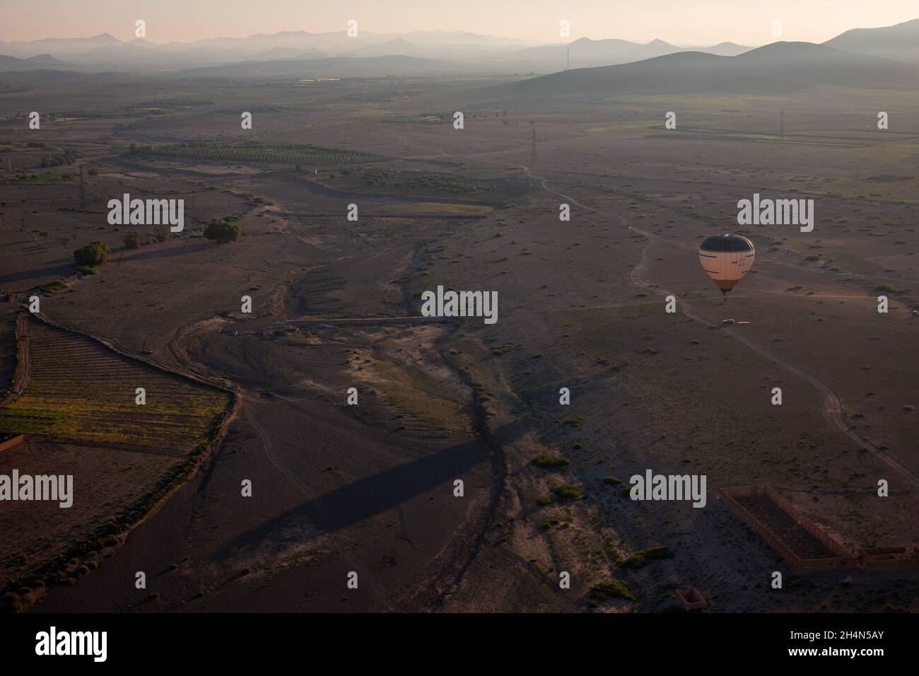 Une vue depuis une montgolfière du désert et des plantations près de Marrakech, lever du soleil en avril, Maroc Banque D'Images