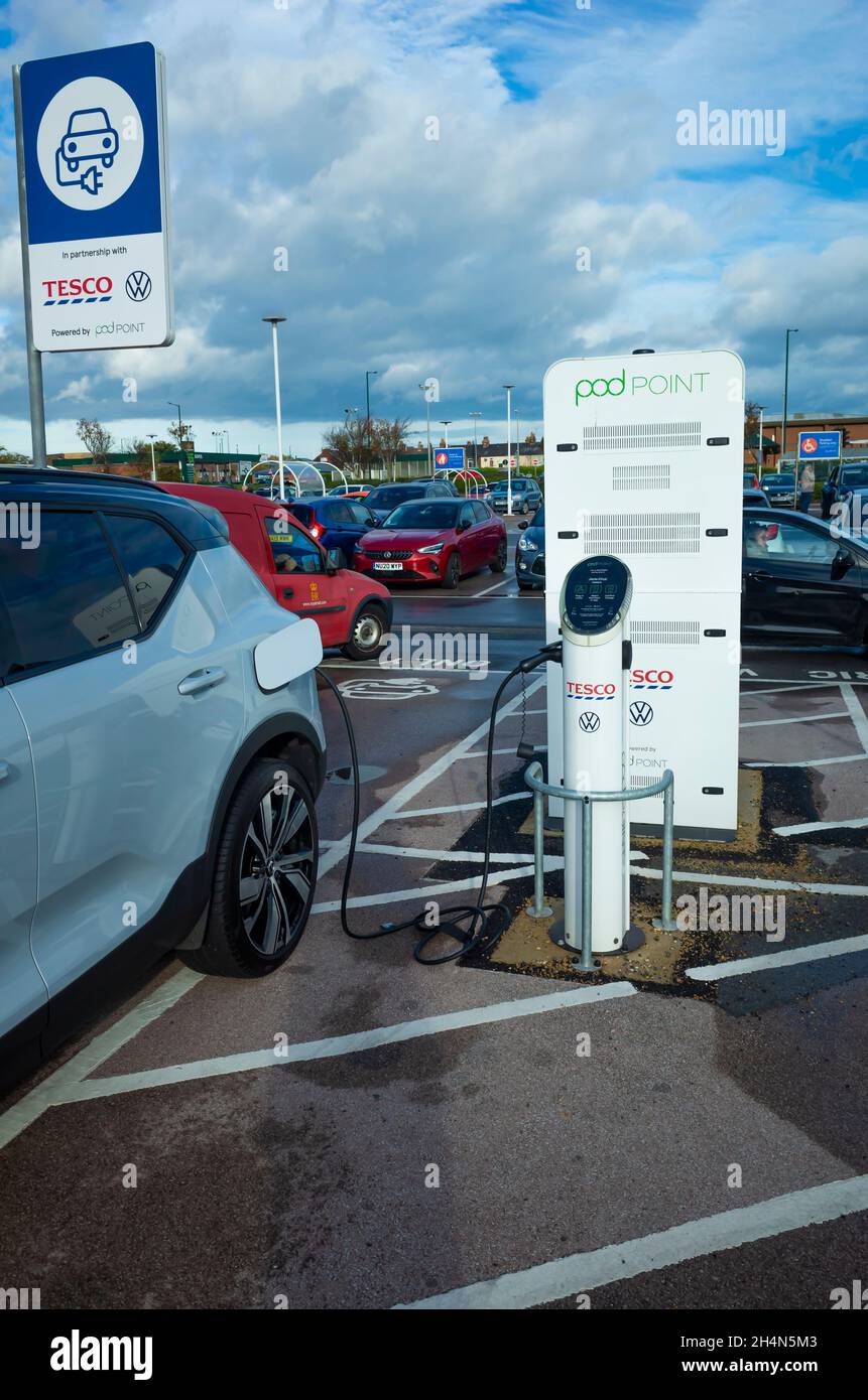 Volvo SUV en charge sur le point de recharge de Pod point dans un parking commercial de Tesco dans le nord du Yorkshire de Redcar Banque D'Images