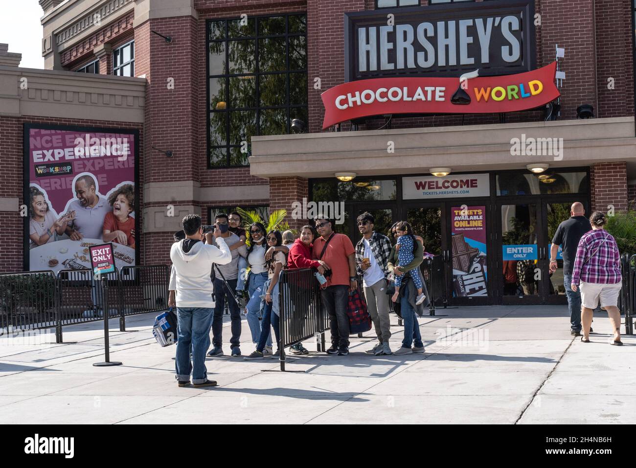 Hershey, Pennsylvanie - 15 octobre 2021 : groupe de touristes Prenez une photo de groupe à l'extérieur de l'entrée du Chocolate World de Hershey Banque D'Images