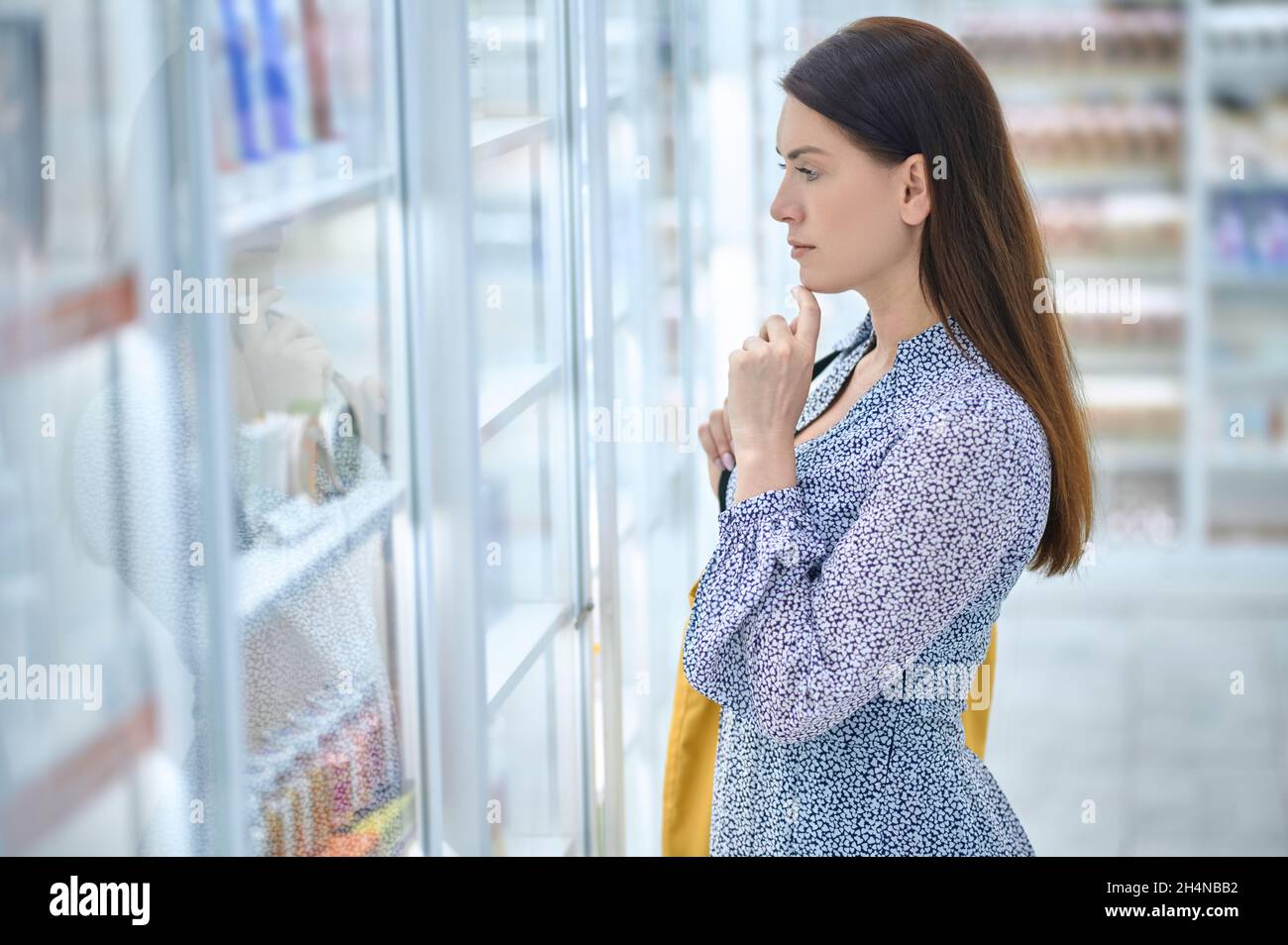 Femme pensive devant les étagères avec des médicaments Banque D'Images