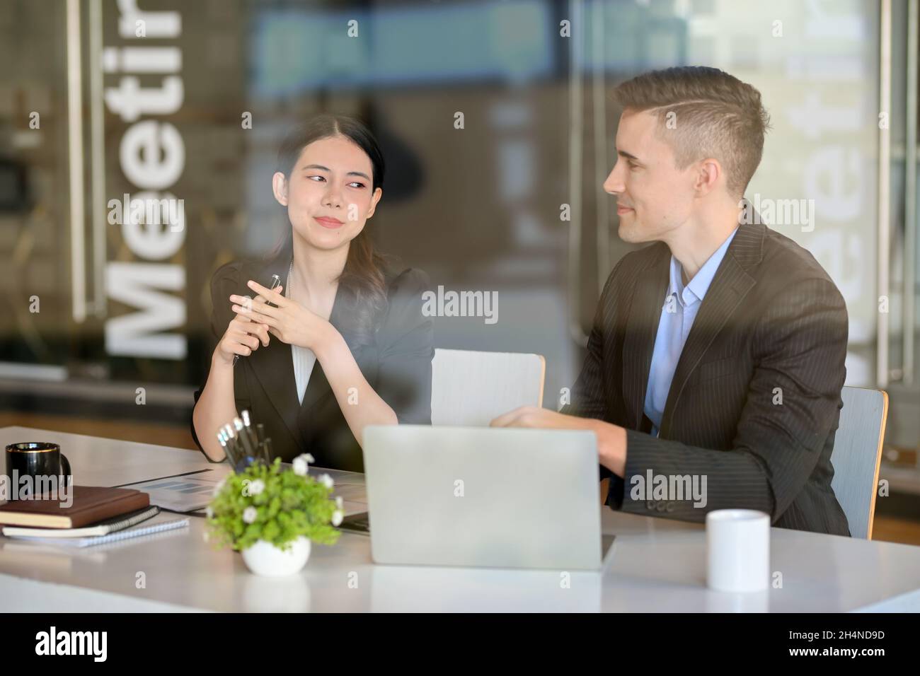 Homme d'affaires intelligent ayant une réunion en plein air avec sa partenaire d'affaires dans un espace de travail commun au café-restaurant. Banque D'Images