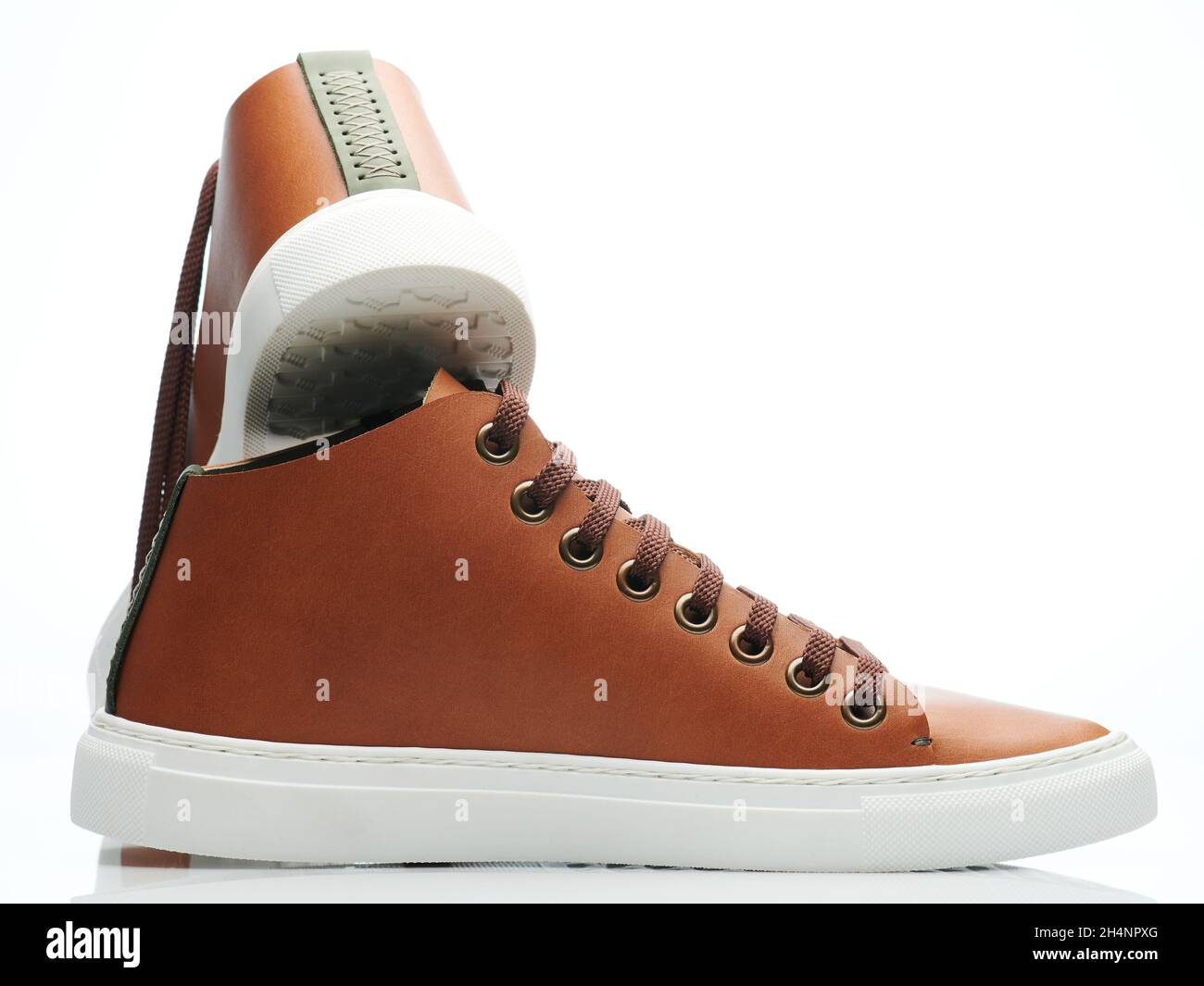 Élégantes chaussures sneaker en cuir marron sur fond blanc studio Banque D'Images