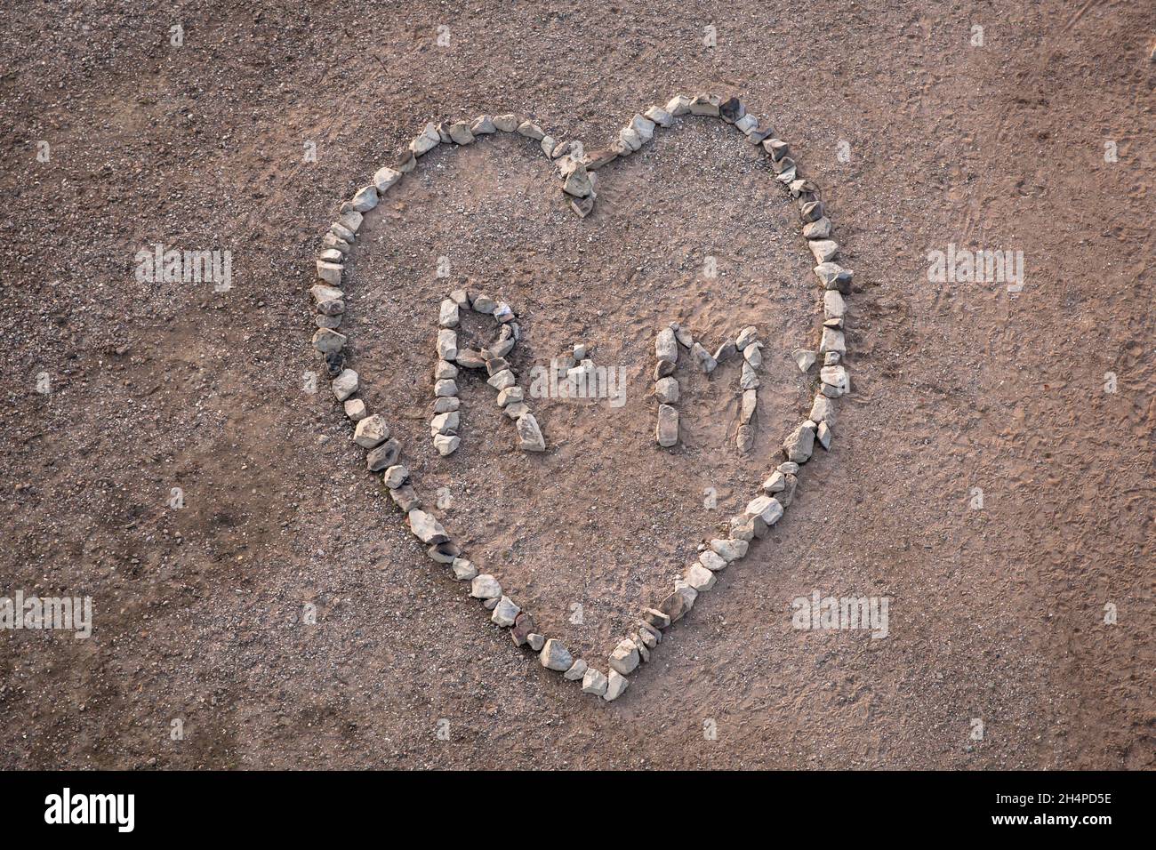Un grand coeur ( environ 4 x 5 mètres ) fait de pierres de basalte du renforcement de la rive du Rhin dans le district de Poll, Cologne, Allemagne. ei Banque D'Images