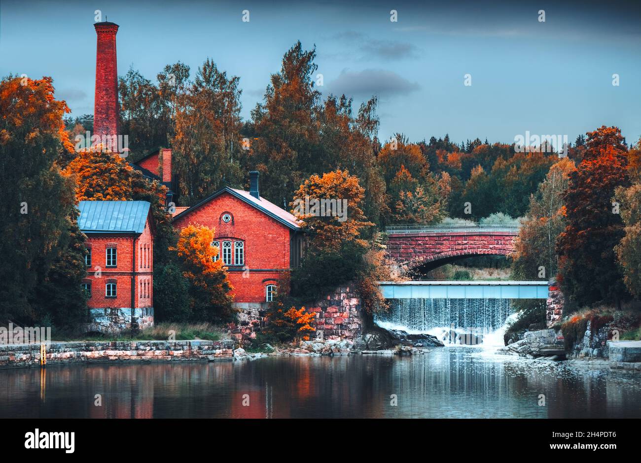 Paysage d'automne.Ancienne architecture.Bâtiments en briques rouges près de l'eau.Ville historique.Pont en pierre au-dessus de la petite cascade.Saison d'automne Moody.Helsinki Banque D'Images