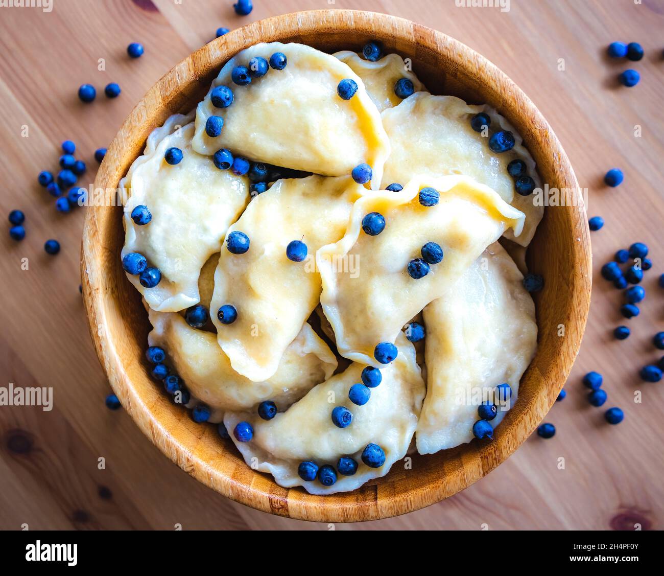 Boulettes sucrées aux myrtilles fraîches servies dans un bol en bois.Dessert slave, vareniki.Cuisine traditionnelle.Boulettes d'emballage faites maison. Banque D'Images