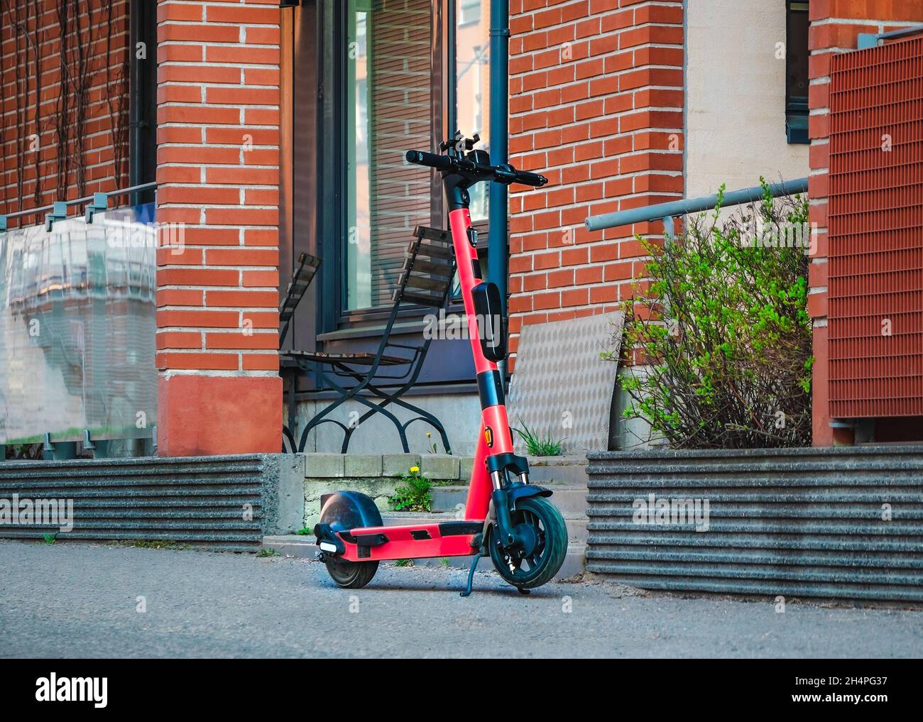 Location de Kick-scooter électrique sur le trottoir de la rue devant le bâtiment mural en briques.E-scooter pour le partage public dans le centre-ville européen. Banque D'Images