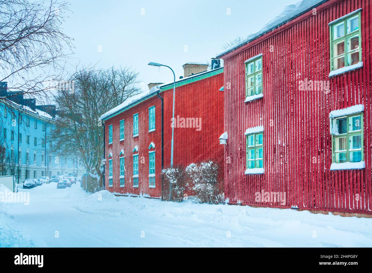 Tempête de neige à Helsinki.Belle scène finlandaise d'hiver.Façades de bâtiments colorées dans une rue couverte de neige.Vieilles maisons en bois rouge en ville en Finlande Banque D'Images