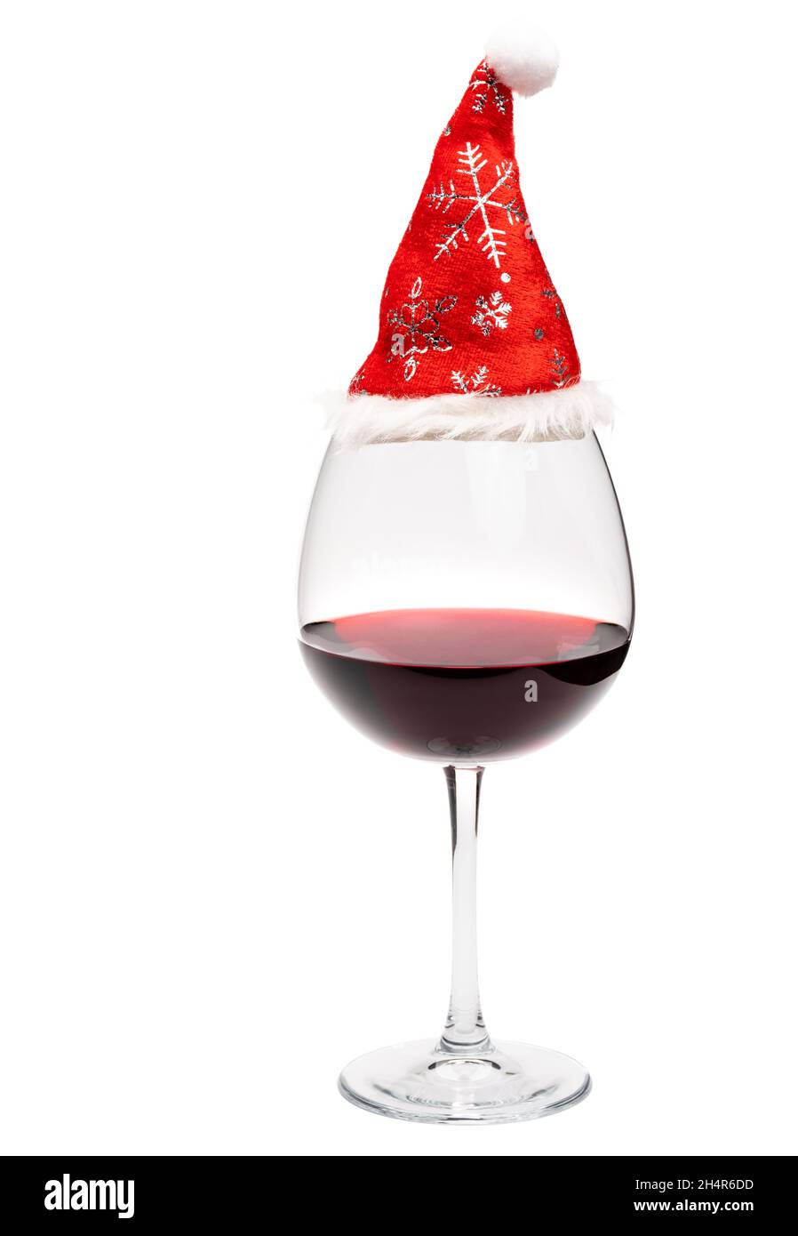 Verre de vin rouge avec chapeau de Père Noël isolé sur fond blanc - concept de boisson de noël Banque D'Images
