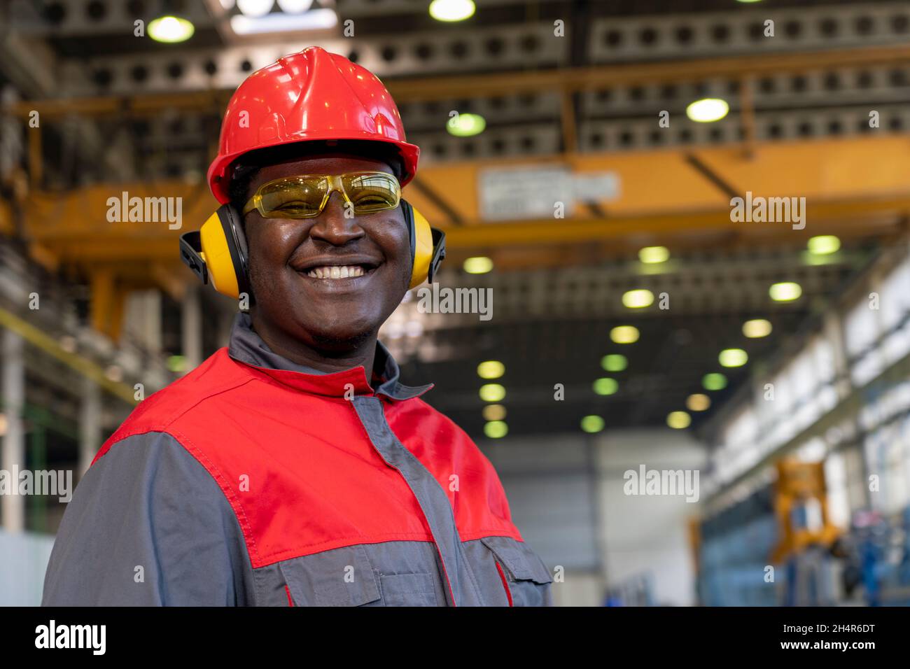 Sourire travailleur américain africain en équipement de protection individuelle tenir le presse-papiers et regarder la caméra.Portrait du travailleur industriel noir . Banque D'Images