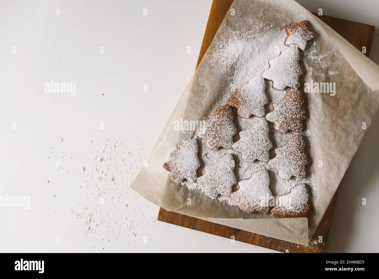 Arbre de Noël en pain d'épice parsemé de sucre en poudre sur parchemin Banque D'Images