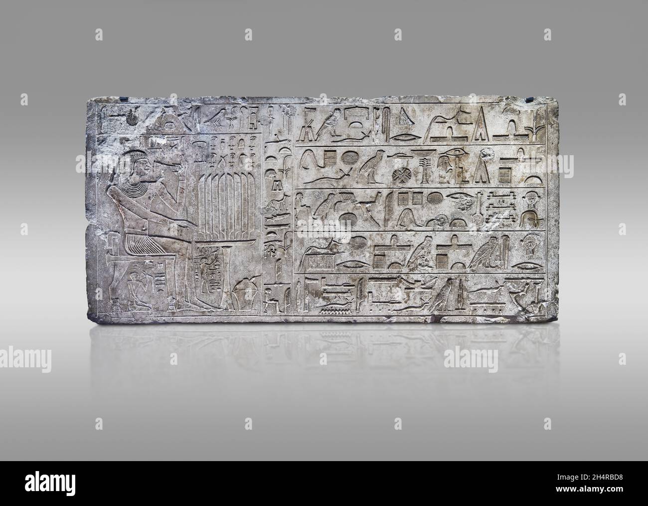 Ancien soulagement de linteau égyptien de la tombe de mastaba de l'ISI, 2350-2297 av. J.-C., Thèbes.Musée du Louvre E 14329.Repas funéraire; homme assis sur un pied de lion s Banque D'Images