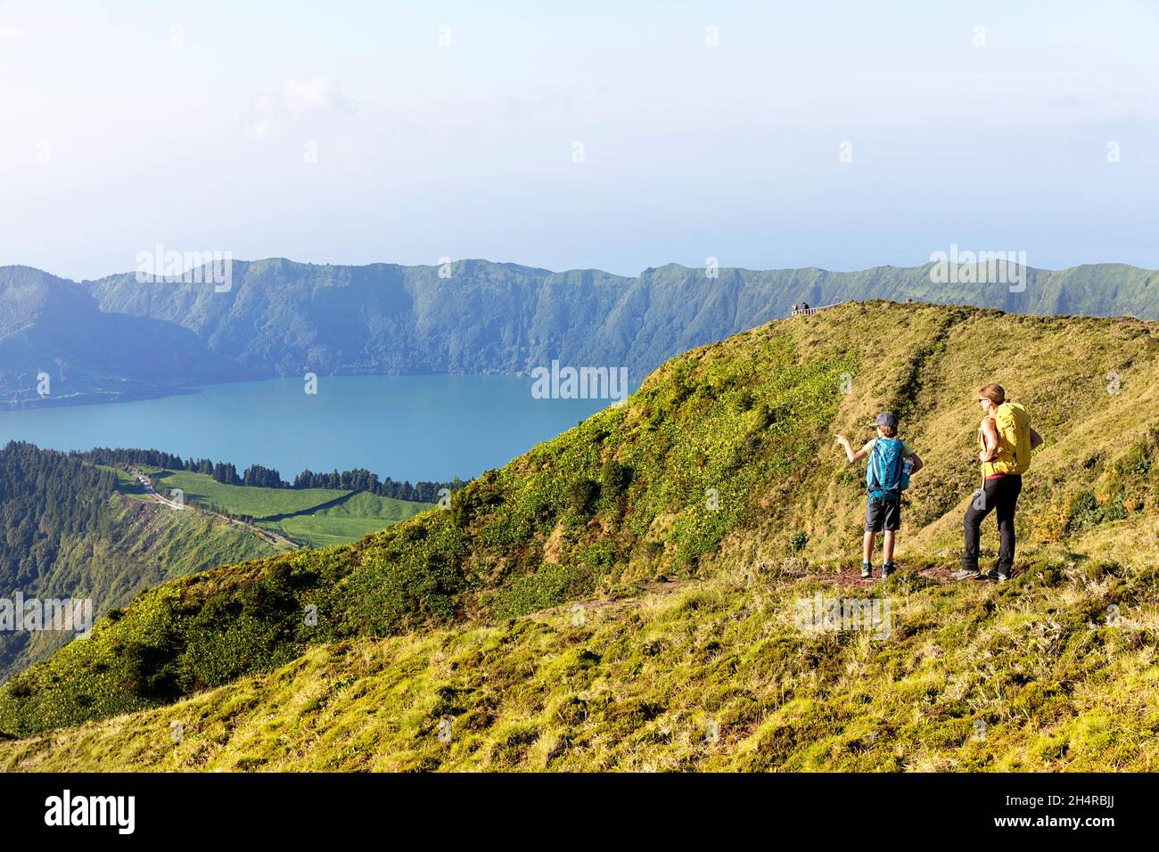 Mère et fils randonnée à Miradouro da Boca do Inferno point de vue avec Lagoa Verde, Lagoa Azul et l'océan en arrière-plan. Sete Cidades, Açores Banque D'Images