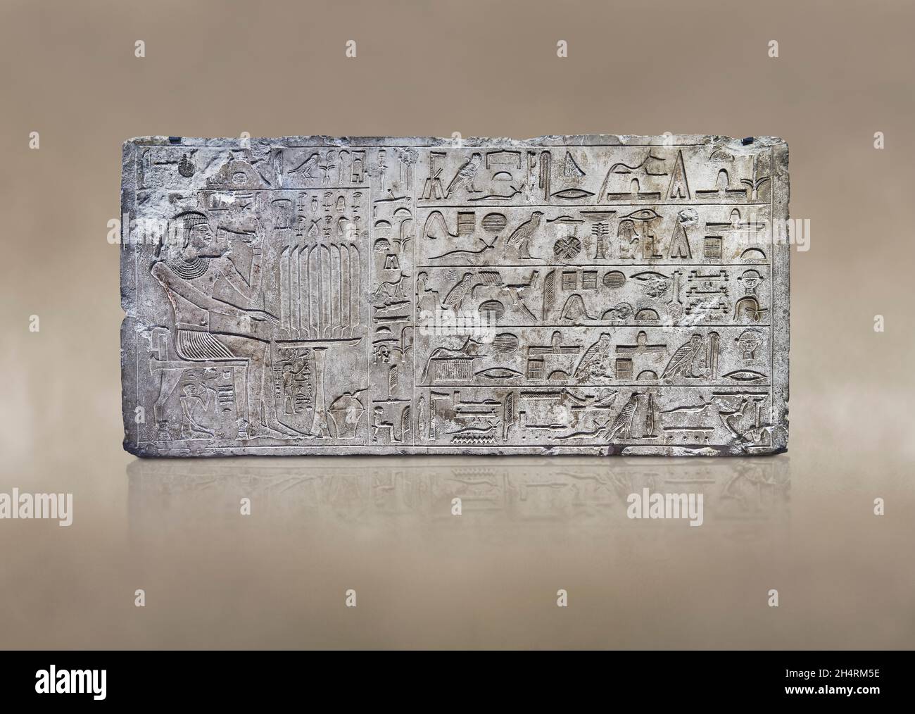 Ancien soulagement de linteau égyptien de la tombe de mastaba de l'ISI, 2350-2297 av. J.-C., Thèbes.Musée du Louvre E 14329.Repas funéraire; homme assis sur un pied de lion s Banque D'Images