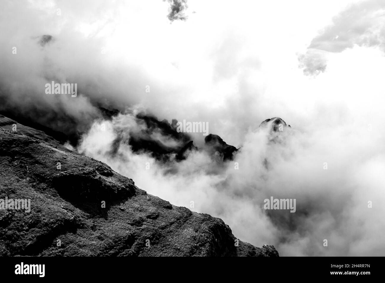 Les sommets déchiquetés des montagnes du Drakensberg, en Afrique du Sud, entourés de nuages en noir et blanc.Ces falaises abruptes emblématiques et ces pics dentelés forme Banque D'Images