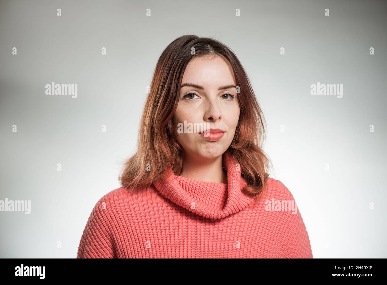 jeune femme à tête rouge portrait en chandail rose sur fond de studio Banque D'Images