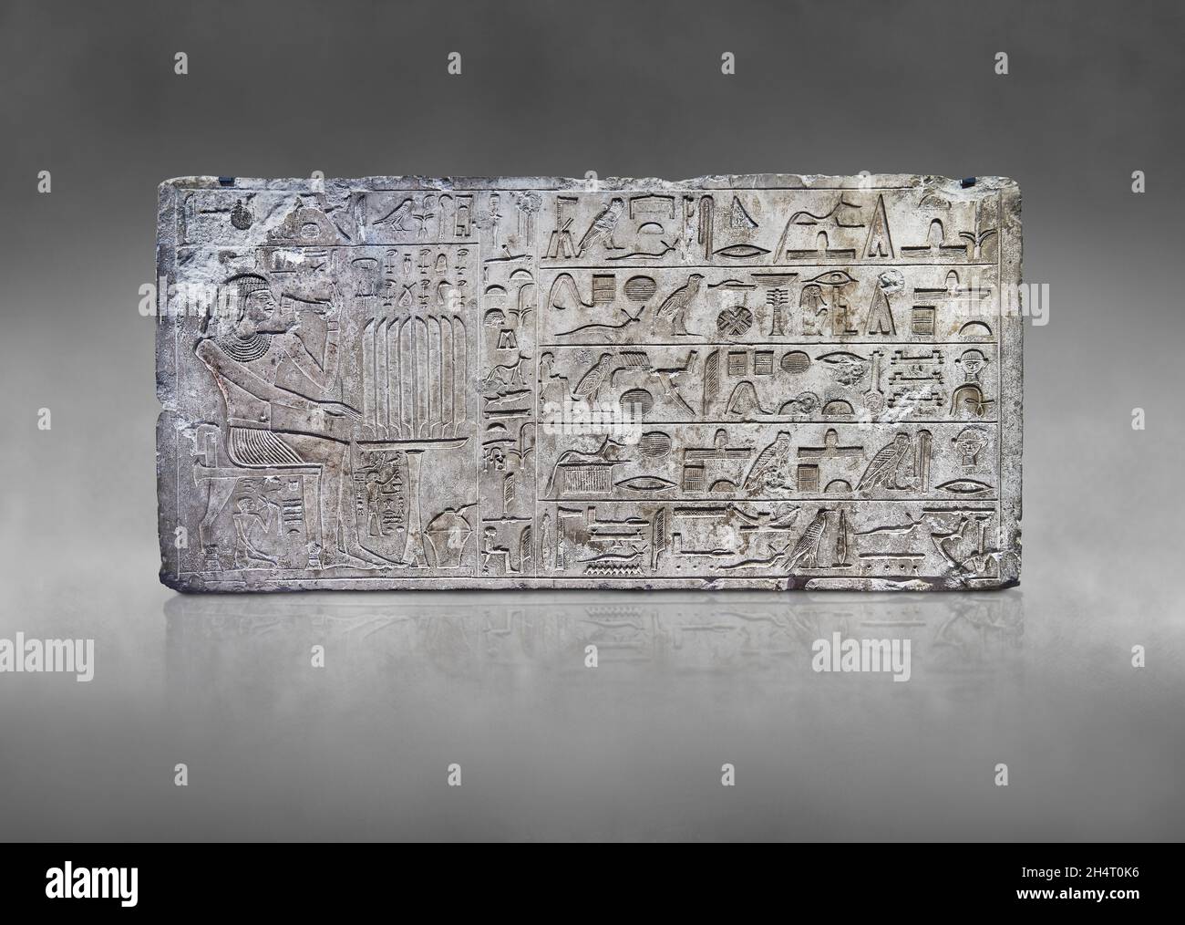 Ancien soulagement de linteau égyptien de la tombe de mastaba de l'ISI, 2350-2297 av. J.-C., Thèbes.Musée du Louvre E 14329.Repas funéraire; homme assis sur un pied de lion s Banque D'Images